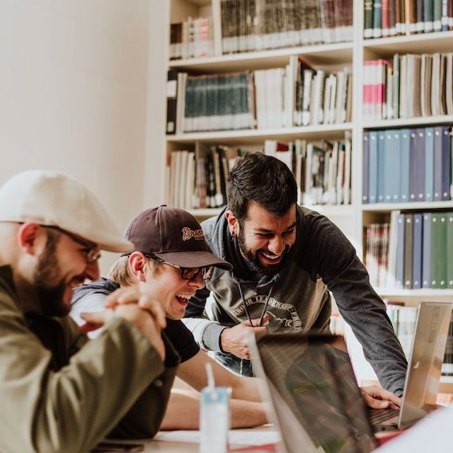 Equipo de emprendedores sonriendo al ver una laptop