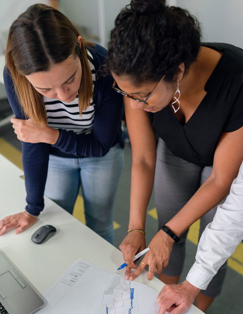 Fotografía de dos mujeres realizando la planeación de un proyecto de emprendimiento